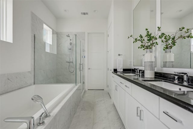 bathroom featuring a sink, a shower stall, a bath, and marble finish floor