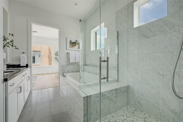 bathroom with walk in shower, a garden tub, vanity, and tile patterned floors