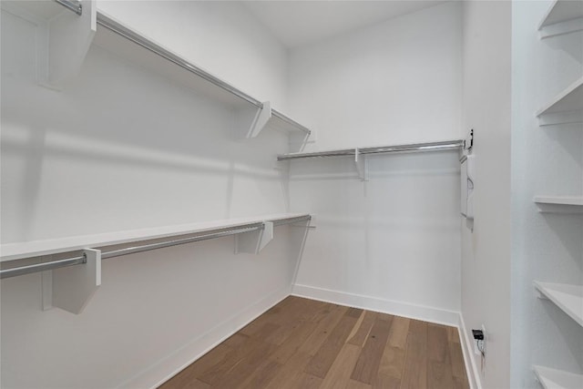 walk in closet with wood finished floors