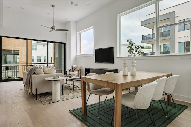 dining space featuring a ceiling fan, light wood-style flooring, and visible vents