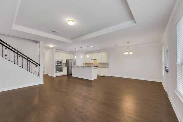 19612 Dunstan Beacon Ln, Pflugerville, TX 78660 - unfurnished living room with a raised ceiling, a chandelier, dark wood-style flooring, crown molding, and baseboards