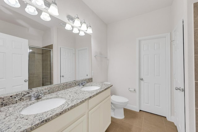 full bathroom featuring a sink, double vanity, toilet, and a stall shower