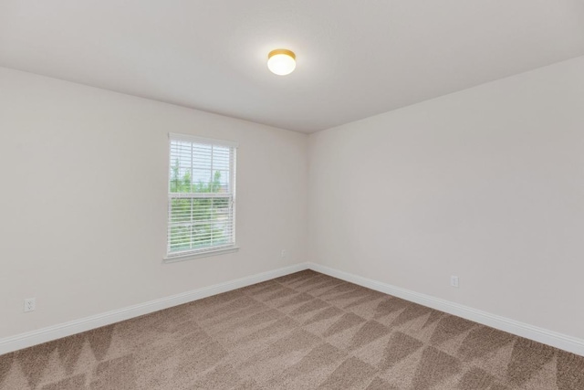 carpeted spare room with baseboards