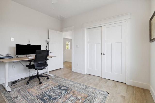 office with baseboards and light wood-style flooring
