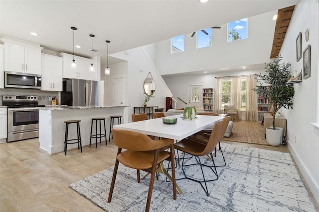 dining space featuring a high ceiling and recessed lighting