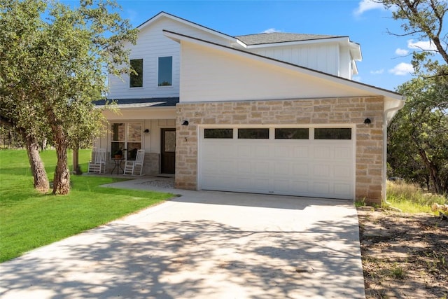 view of front of home with stone siding, concrete driveway, a porch, and a front lawn