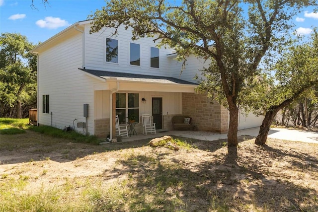 view of front of house with stone siding and a patio
