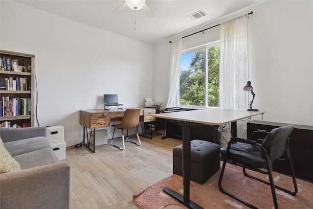 office with light wood finished floors, a ceiling fan, and visible vents