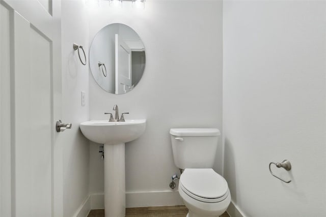 bathroom with toilet and baseboards
