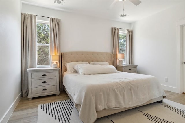 bedroom featuring light wood-type flooring, visible vents, and multiple windows