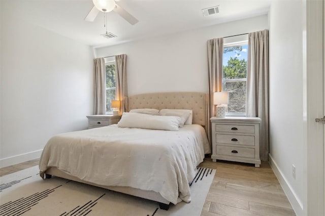 bedroom featuring baseboards, light wood-style floors, visible vents, and a ceiling fan