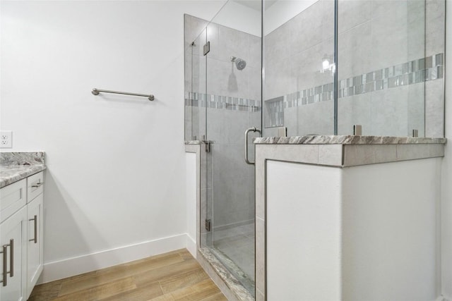 bathroom featuring a shower stall, vanity, and wood finished floors