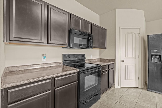 1021 Polmont Ct, Seguin, TX 78155 - kitchen with light tile patterned floors, dark brown cabinets, light stone counters, and black appliances