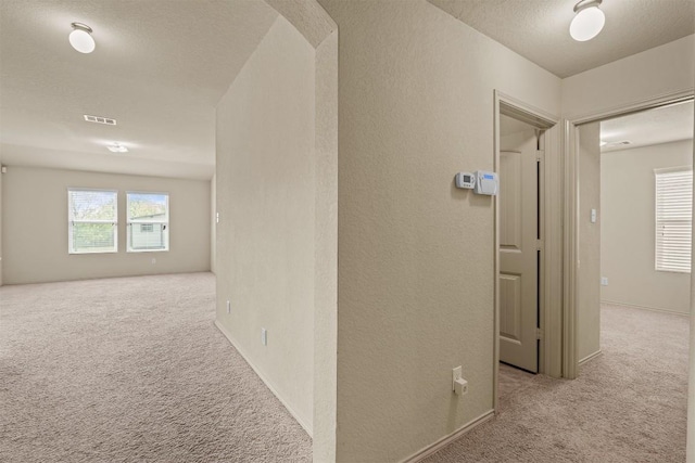1021 Polmont Ct, Seguin, TX 78155 - hallway featuring a textured wall, a textured ceiling, carpet flooring, and visible vents