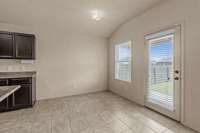 1021 Polmont Ct, Seguin, TX 78155 - unfurnished dining area with vaulted ceiling and light tile patterned floors