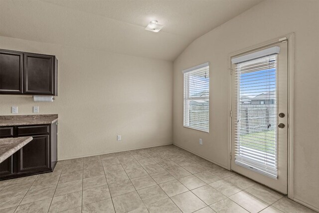 1021 Polmont Ct, Seguin, TX 78155 - unfurnished dining area featuring vaulted ceiling and light tile patterned floors