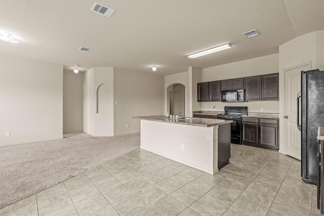 1021 Polmont Ct, Seguin, TX 78155 - kitchen featuring light tile patterned floors, visible vents, open floor plan, arched walkways, and black appliances