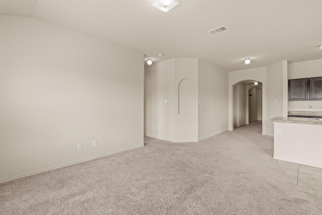 1021 Polmont Ct, Seguin, TX 78155 - unfurnished living room with light colored carpet, arched walkways, baseboards, and visible vents