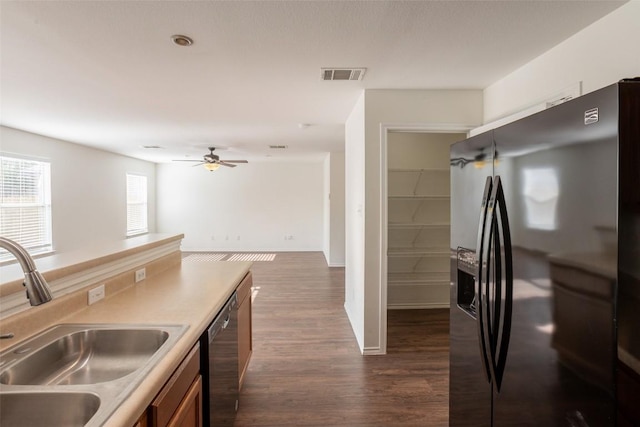 kitchen with a sink, visible vents, dishwasher, dark wood-style flooring, and refrigerator with ice dispenser