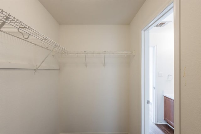 spacious closet with visible vents and dark wood-style floors