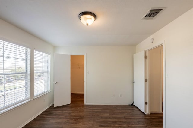 interior space with baseboards, a wealth of natural light, visible vents, and wood finished floors