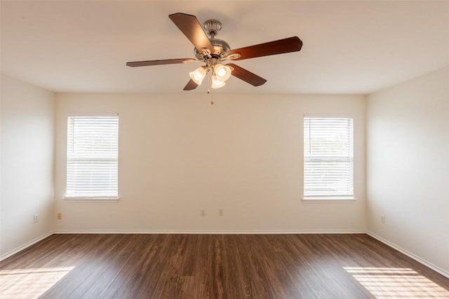 empty room featuring baseboards, ceiling fan, and dark wood-style floors