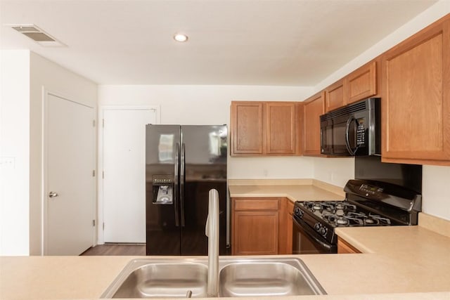 kitchen with recessed lighting, visible vents, a sink, black appliances, and light countertops