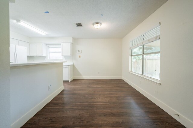 1304 Green Terrace Dr, Round Rock, TX 78664 - unfurnished room featuring plenty of natural light, dark wood-style floors, baseboards, and a textured ceiling