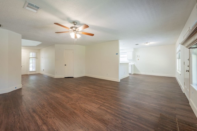 1304 Green Terrace Dr, Round Rock, TX 78664 - unfurnished living room featuring a ceiling fan, dark wood-style flooring, baseboards, and a textured ceiling