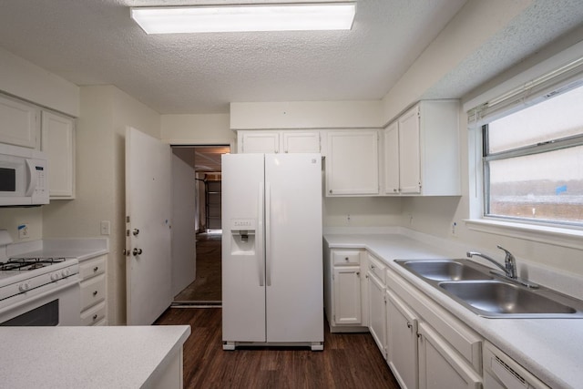 1304 Green Terrace Dr, Round Rock, TX 78664 - kitchen featuring white appliances, a sink, dark wood-style flooring, white cabinets, and a textured ceiling