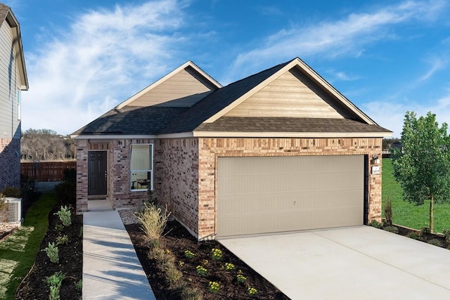 view of front of house featuring central AC, brick siding, driveway, a garage, and a shingled roof