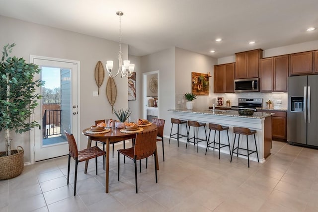 dining space featuring a chandelier, light tile patterned flooring, and recessed lighting