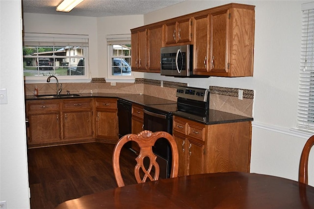 1007 N Bishop St, San Marcos, TX 78666 - kitchen featuring stainless steel appliances, a sink, brown cabinetry, and a textured ceiling
