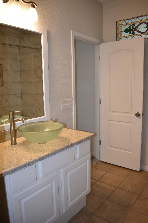 1007 N Bishop St, San Marcos, TX 78666 - bathroom with vanity, tile patterned floors, and a textured wall