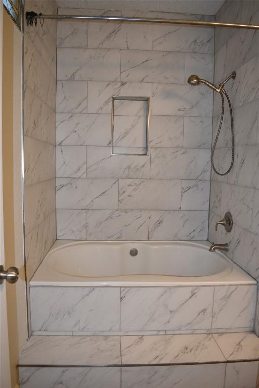 1007 N Bishop St, San Marcos, TX 78666 - bathroom featuring tiled shower / bath