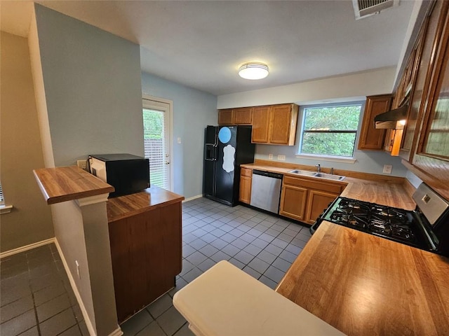 4402 Keota Dr, Austin, TX 78749 - kitchen with gas stove, stainless steel dishwasher, black fridge with ice dispenser, and butcher block countertops