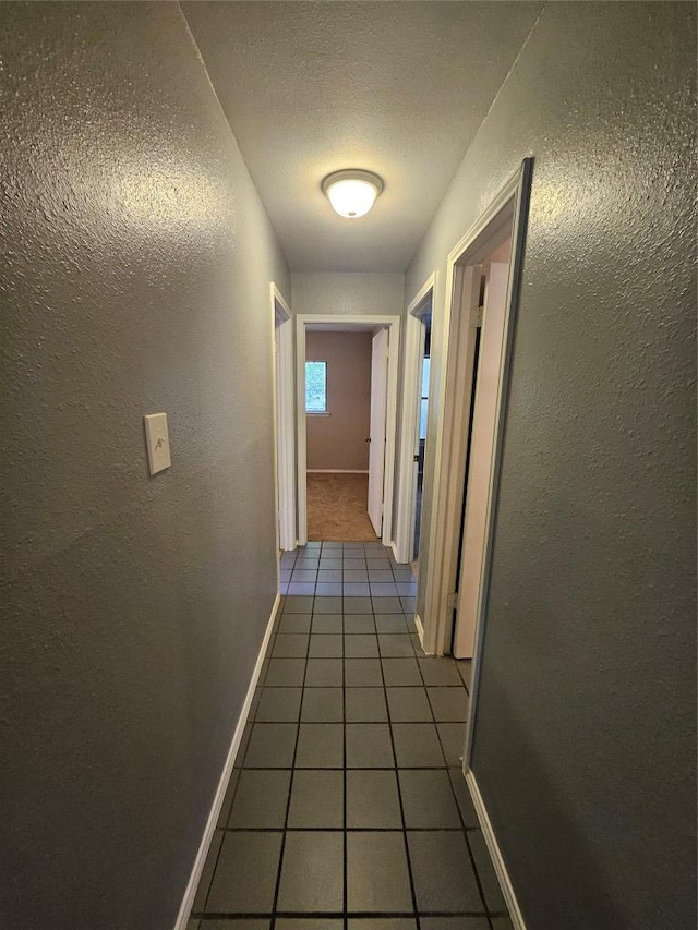 4402 Keota Dr, Austin, TX 78749 - hall featuring baseboards, tile patterned flooring, and a textured wall