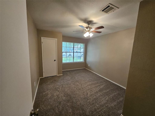 4402 Keota Dr, Austin, TX 78749 - empty room with dark carpet, ceiling fan, baseboards, and visible vents