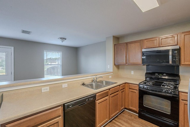 kitchen with light countertops, visible vents, black appliances, and a sink