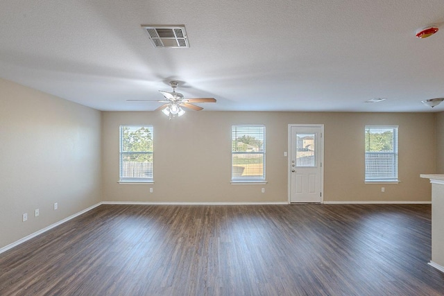 interior space featuring a ceiling fan, baseboards, dark wood-style floors, and visible vents