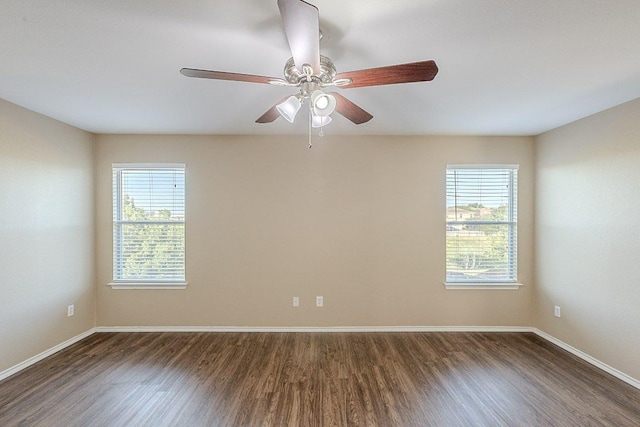 empty room featuring baseboards, ceiling fan, and dark wood-style floors