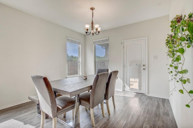 dining area with a notable chandelier, baseboards, and wood finished floors