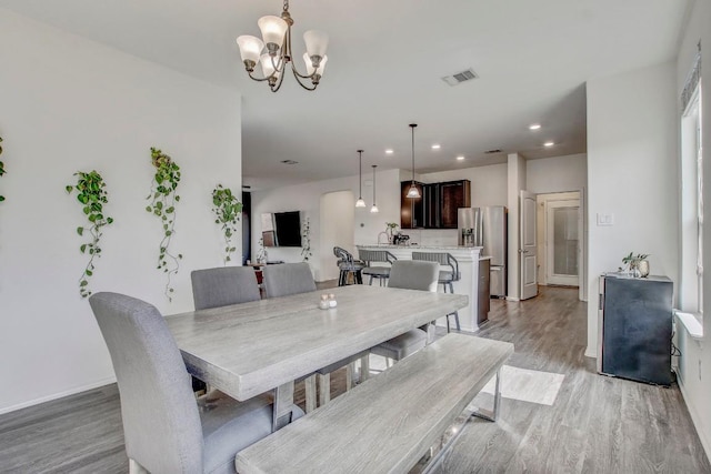 dining room with recessed lighting, light wood-style floors, visible vents, and a notable chandelier