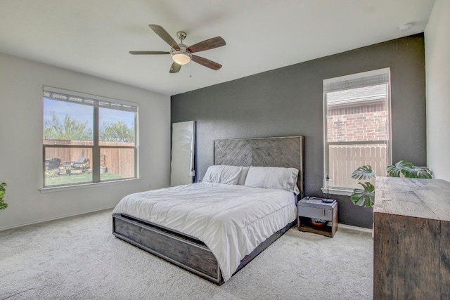 carpeted bedroom with ceiling fan and baseboards