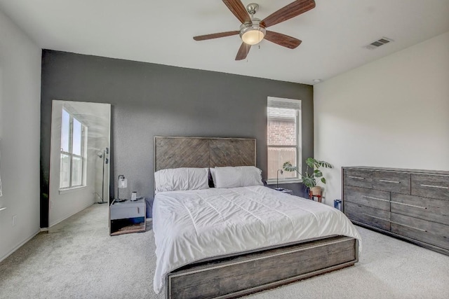 carpeted bedroom featuring visible vents, baseboards, and ceiling fan