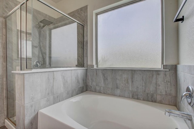full bath with a bath and a shower stall