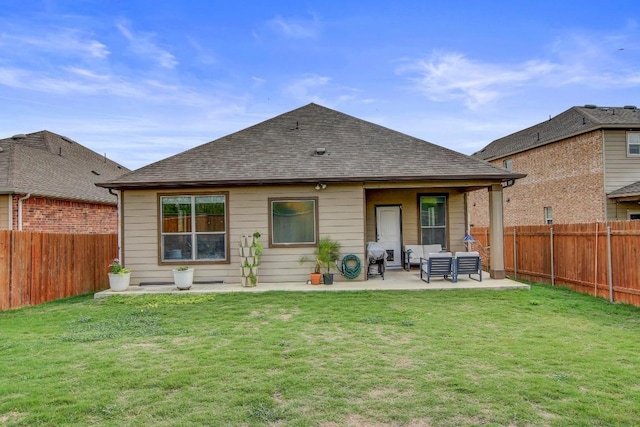 rear view of property featuring a lawn, a patio, and a fenced backyard