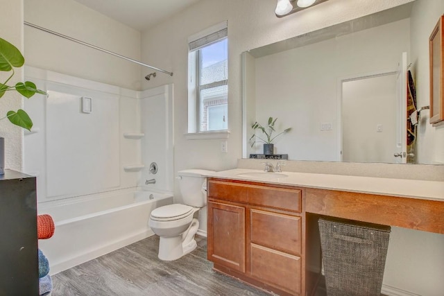 bathroom with toilet, bathing tub / shower combination, vanity, and wood finished floors