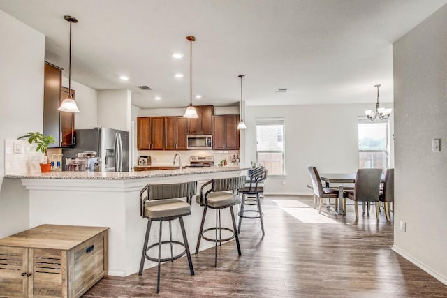 kitchen featuring baseboards, an inviting chandelier, appliances with stainless steel finishes, and dark wood-type flooring