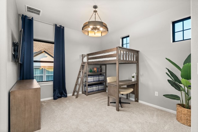 carpeted bedroom featuring baseboards, a chandelier, and visible vents